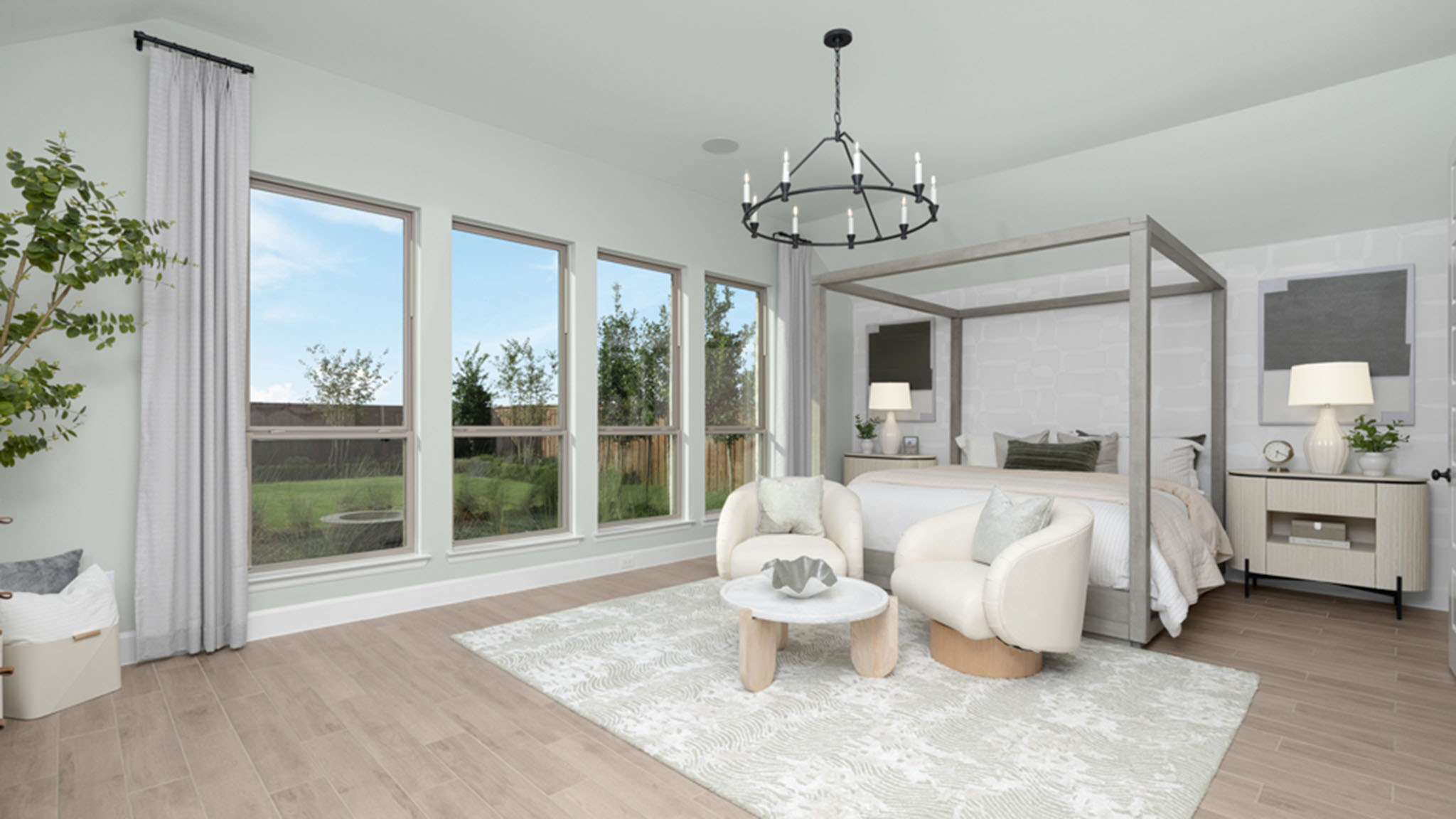 Primary bedroom with canopy bed frame, black chandelier, and large windows overlooking the backyard.