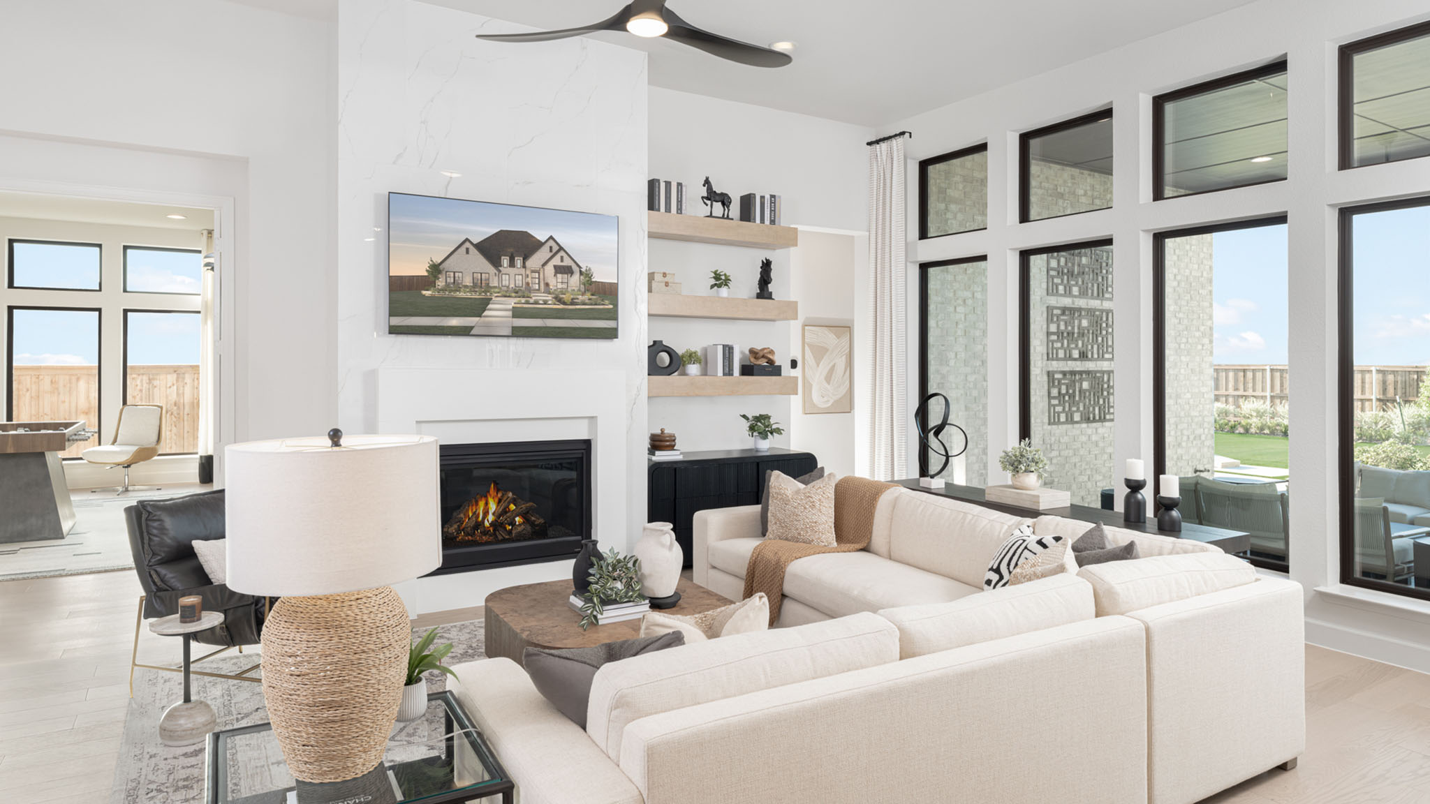 Living room with marble fireplace surround, cream sectional, and floating shelves.